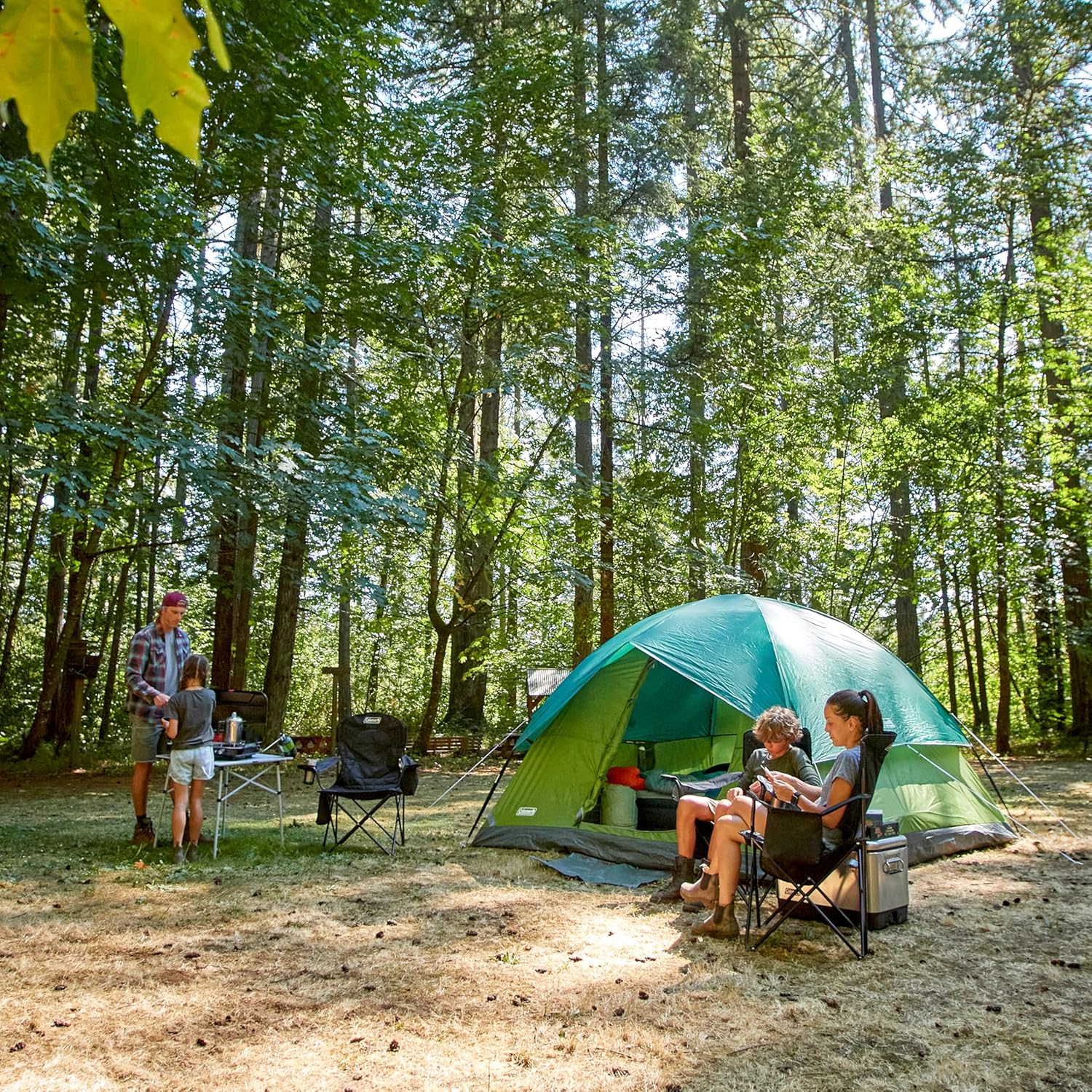 Camp setup at golden hour with organized gear bins and a lantern